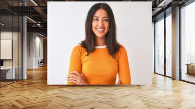 Young beautiful chinese woman wearing orange t-shirt standing over isolated white background happy face smiling with crossed arms looking at the camera. Positive person. Wall mural