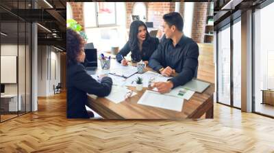 Young beautiful couple applying for mortgage. Sitting smiling happy meeting with real state agent signing mortgage loan at bank Wall mural