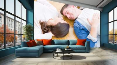 Young beautiful couple relaxing lying on the floor around cardboard boxes at home, smiling happy moving to a new house Wall mural