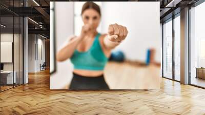 Young beautiful hispanic woman boxing at sport center Wall mural