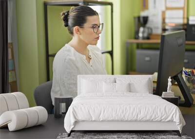 Young beautiful hispanic woman business worker using computer working at the office Wall mural