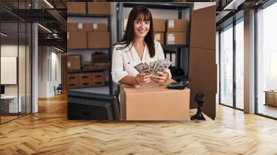 Young beautiful hispanic woman ecommerce business worker counting dollars at office Wall mural