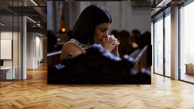 Young beautiful hispanic woman praying on a church bench at Augustinian Church in Vienna Wall mural