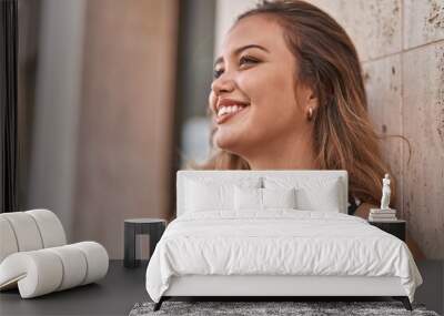 Young beautiful hispanic woman smiling confident looking to the side at street Wall mural