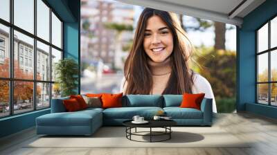 Young beautiful hispanic woman smiling confident standing at street Wall mural