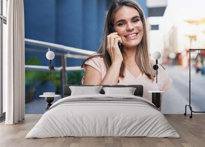 Young beautiful hispanic woman smiling confident talking on the smartphone at street Wall mural