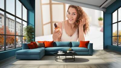 Young beautiful hispanic woman smiling confident using hair treatment at bedroom Wall mural