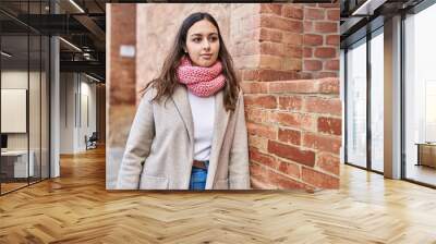 Young beautiful hispanic woman standing with relaxed expression wearing scarf at street Wall mural