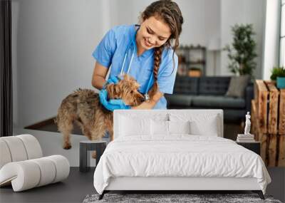 Young beautiful hispanic woman veterinarian smiling confident examining dog at home Wall mural