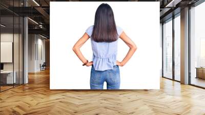 Young beautiful latin girl wearing casual clothes standing backwards looking away with arms on body Wall mural