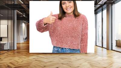 Young beautiful woman wearing casual clothes doing happy thumbs up gesture with hand. approving expression looking at the camera showing success. Wall mural