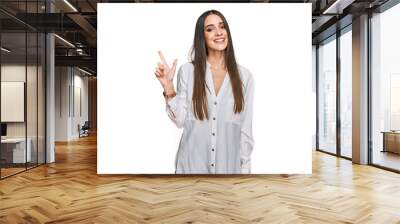 Young beautiful woman wearing casual white shirt with a big smile on face, pointing with hand finger to the side looking at the camera. Wall mural