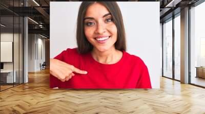 Young beautiful woman wearing red casual t-shirt standing over isolated white background with surprise face pointing finger to himself Wall mural