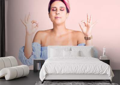 Young beautiful woman with pink hair wearing casual clothes relaxed and smiling with eyes closed doing meditation gesture with fingers. yoga concept. Wall mural