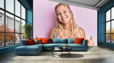 Young blonde girl wearing casual clothes looking confident with smile on face, pointing oneself with fingers proud and happy. Wall mural