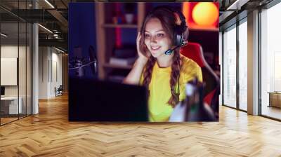 Young blonde woman streamer smiling confident sitting on table at gaming room Wall mural