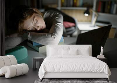 Young blonde woman student sleeping on the desk at library university Wall mural