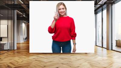 Young blonde woman wearing winter sweater over isolated background showing and pointing up with fingers number two while smiling confident and happy. Wall mural