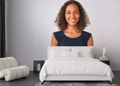 Young brazilian woman wearing blue dress standing over isolated white background happy face smiling with crossed arms looking at the camera. Positive person. Wall mural