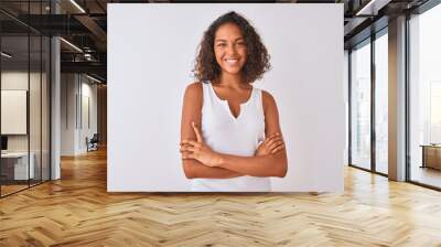 Young brazilian woman wearing casual t-shirt standing over isolated white background happy face smiling with crossed arms looking at the camera. Positive person. Wall mural