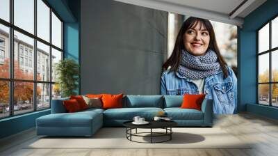 Young brunette woman smiling happy leaning on the wall Wall mural