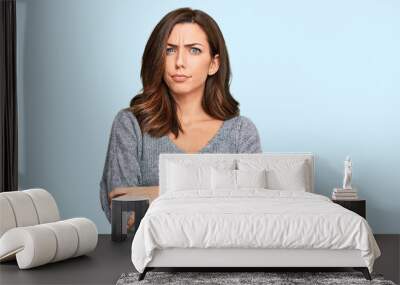 Young brunette woman wearing casual winter sweater skeptic and nervous, disapproving expression on face with crossed arms. negative person. Wall mural