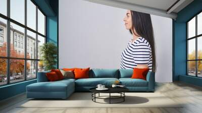 Young brunette woman wearing striped t shirt looking to side, relax profile pose with natural face and confident smile. Wall mural