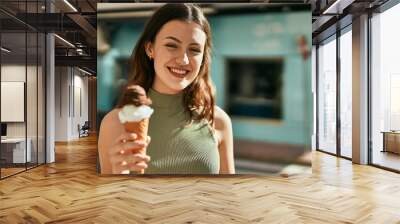 Young caucasian girl smiling happy eating ice cream at the city. Wall mural