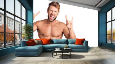 Young caucasian man standing shirtless shouting with crazy expression doing rock symbol with hands up. music star. heavy concept. Wall mural