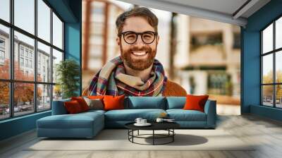 Young caucasian man with beard wearing glasses outdoors on a sunny day Wall mural