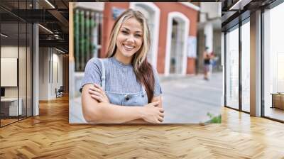 Young caucasian woman outdoors happy face smiling with crossed arms looking at the camera. positive person. Wall mural