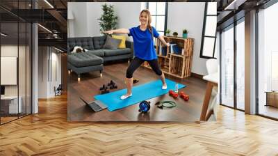 Young caucasian woman smiling confident having online yoga class at home Wall mural