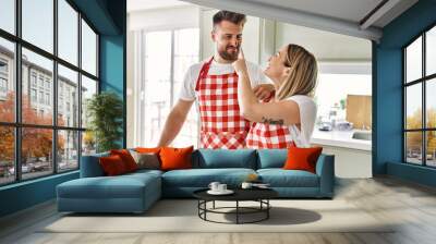 Young couple smiling confident cooking chocolate cake at kitchen Wall mural