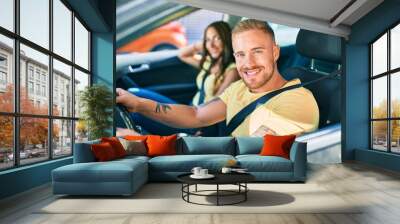 Young couple smiling happy driving car, Wall mural