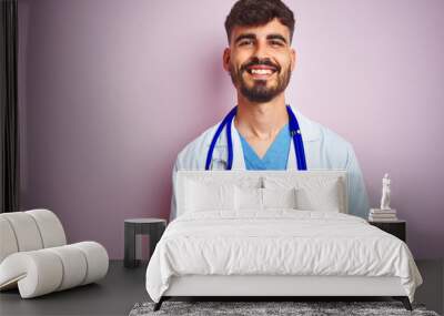 Young doctor man with tattoo wearing stethocope standing over isolated pink background with a happy and cool smile on face. Lucky person. Wall mural