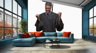 Young graduated african american man over isolated background very happy and excited doing winner gesture with arms raised, smiling and screaming for success. Celebration concept. Wall mural