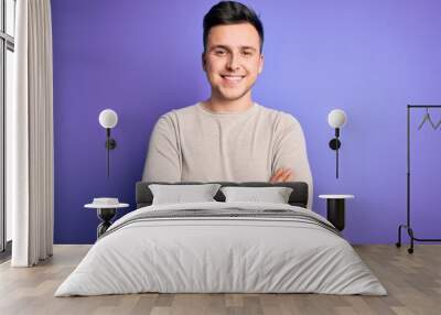 Young handsome caucasian man wearing casual sweater over purple isolated background happy face smiling with crossed arms looking at the camera. Positive person. Wall mural