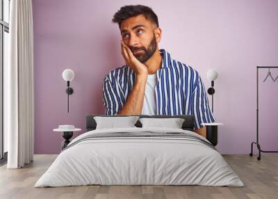 Young handsome indian man wearing summer striped shirt over isolated pink background thinking looking tired and bored with depression problems with crossed arms. Wall mural