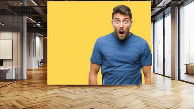 Young handsome man over isolated background afraid and shocked with surprise expression, fear and excited face. Wall mural