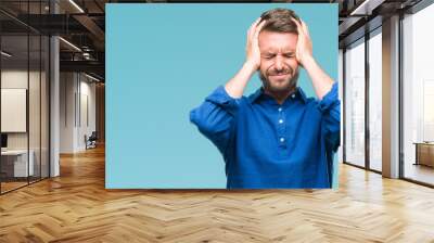 Young handsome man over isolated background suffering from headache desperate and stressed because pain and migraine. Hands on head. Wall mural