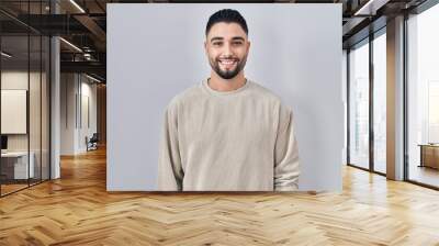 Young handsome man standing over isolated background with a happy and cool smile on face. lucky person. Wall mural