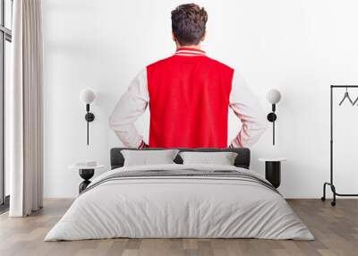 Young handsome man wearing baseball uniform standing backwards looking away with arms on body Wall mural