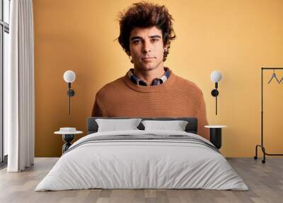 Young handsome man wearing casual shirt and sweater over isolated yellow background looking sleepy and tired, exhausted for fatigue and hangover, lazy eyes in the morning. Wall mural