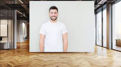 Young handsome man wearing casual white t-shirt over isolated background with a happy and cool smile on face. Lucky person. Wall mural