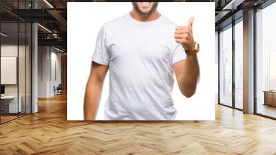 Young handsome man wearing glasses over isolated background doing happy thumbs up gesture with hand. Approving expression looking at the camera with showing success. Wall mural