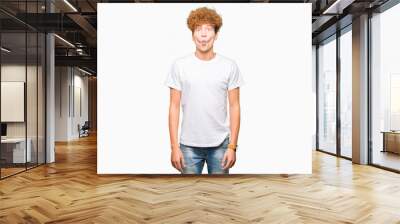 Young handsome man with afro hair wearing casual white t-shirt making fish face with lips, crazy and comical gesture. Funny expression. Wall mural