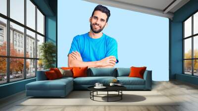 Young handsome man with beard wearing casual t-shirt happy face smiling with crossed arms looking at the camera. positive person. Wall mural