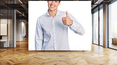 Young hispanic business man wearing business clothes doing happy thumbs up gesture with hand. approving expression looking at the camera showing success. Wall mural