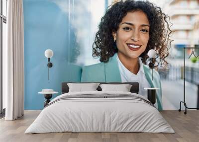 Young hispanic business woman wearing professional look smiling confident at the city leaning on the wall Wall mural