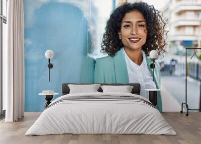 Young hispanic business woman wearing professional look smiling confident at the city leaning on the wall Wall mural